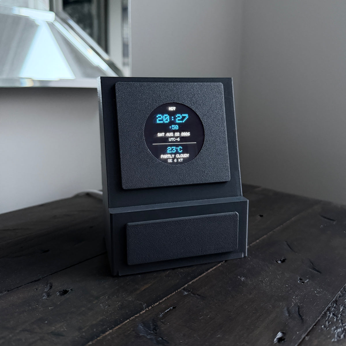 Gray DeskSpotter unit showing the clock and weather mode
