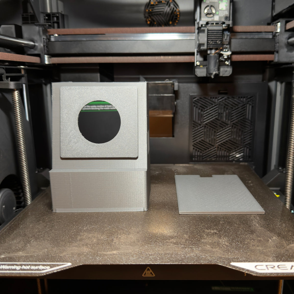 DeskSpotter enclosure being 3D printed in gray filament on the printer bed